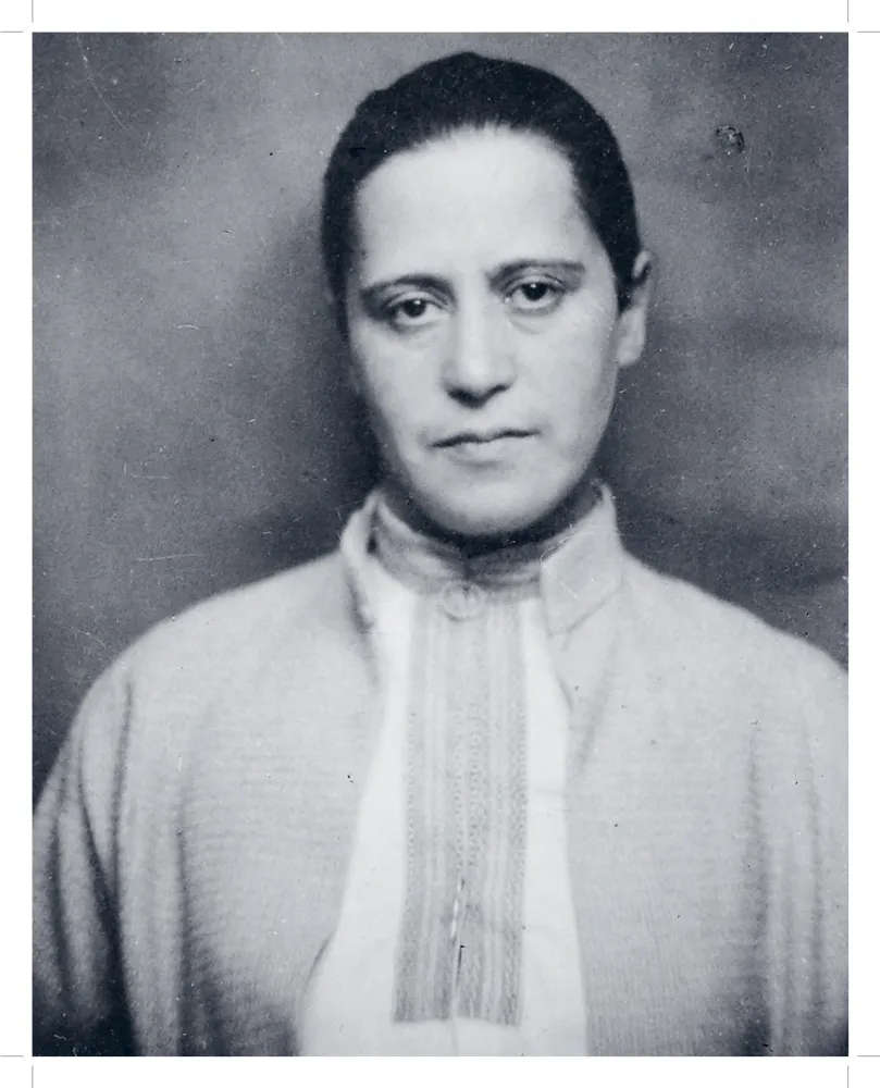Schwarz-weiß-Fotografie einer Frau, die ein Tunika-artiges Oberteil trägt. 
