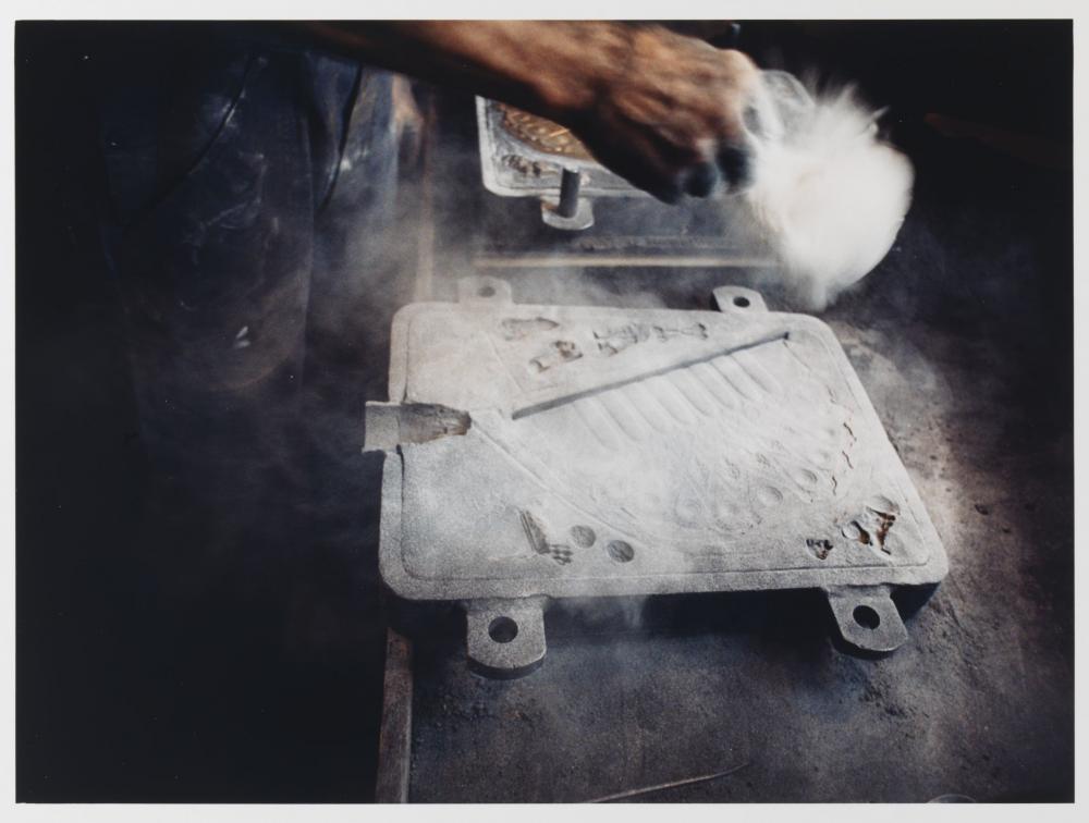 The mold of the Hanukkah lamp is dusted with charcoal dust and molding powder.