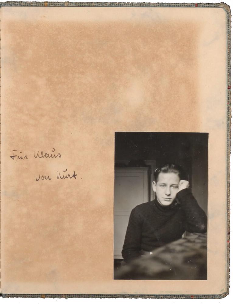 Yellowed page with handwritten dedication alongside black-and-white photo of a teenaged boy
