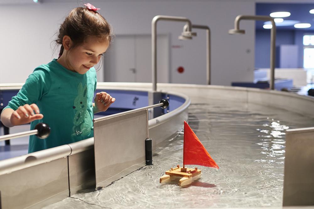 Mädchen an Wasserstation in der Kinderwelt Anoha