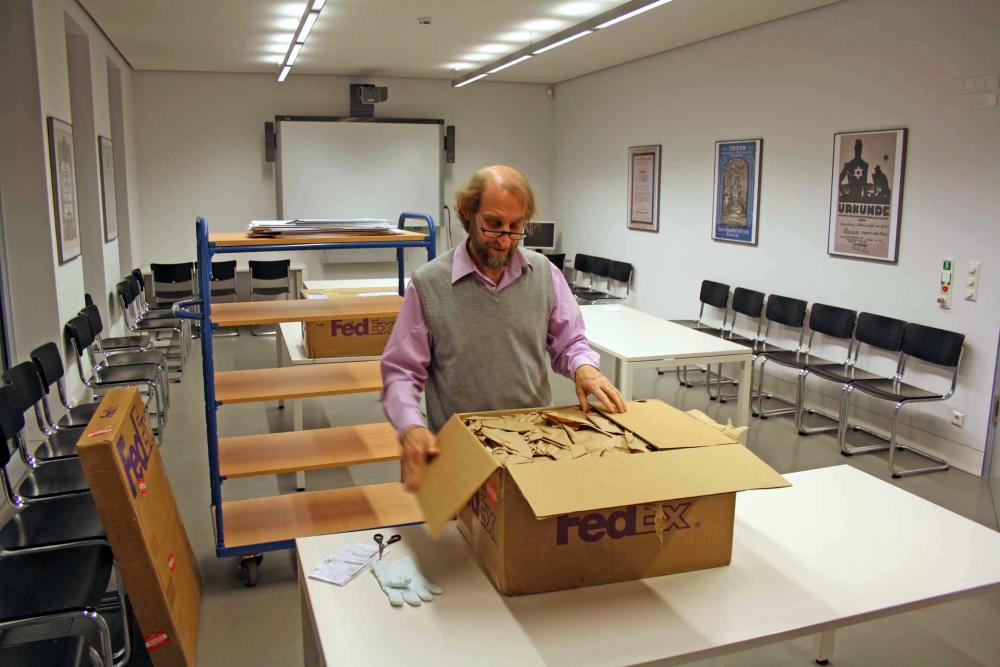 A man opens a cardboard box.