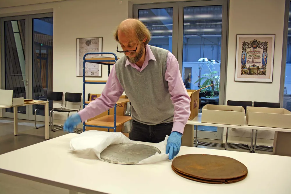 A man unpacks a disk-shaped object.