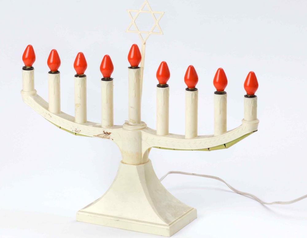 Electric hanukkah lamp made of ivory-colored plastic with screw sockets, orange-red light bulbs, and a power cord