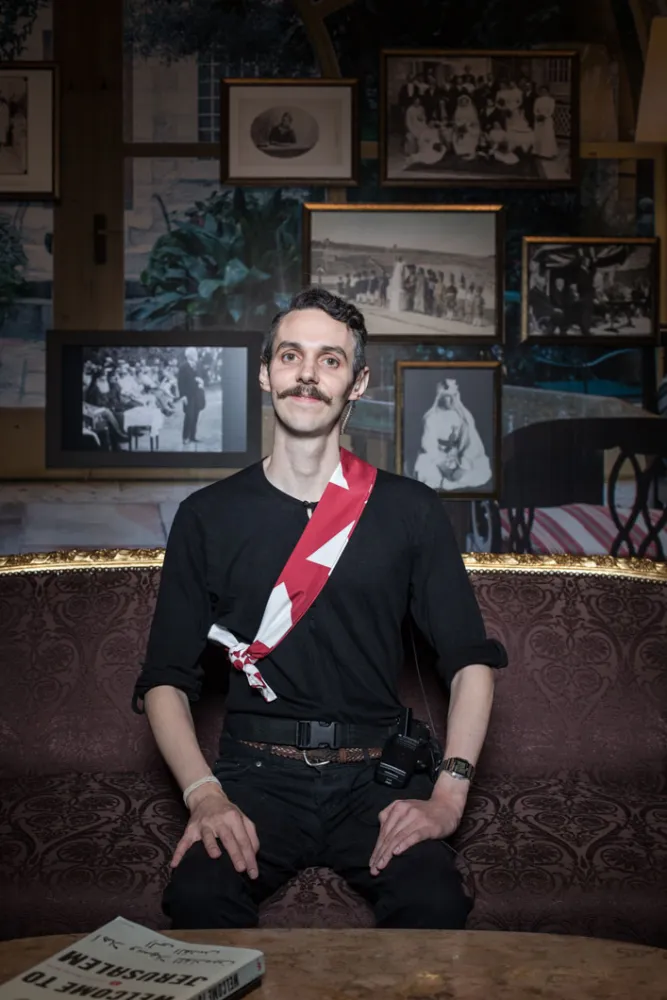 Ein junger Mann sitz in einem Raum der Ausstellung „Welcome to Jerusalem“ im Jüdischen Museum Berlin