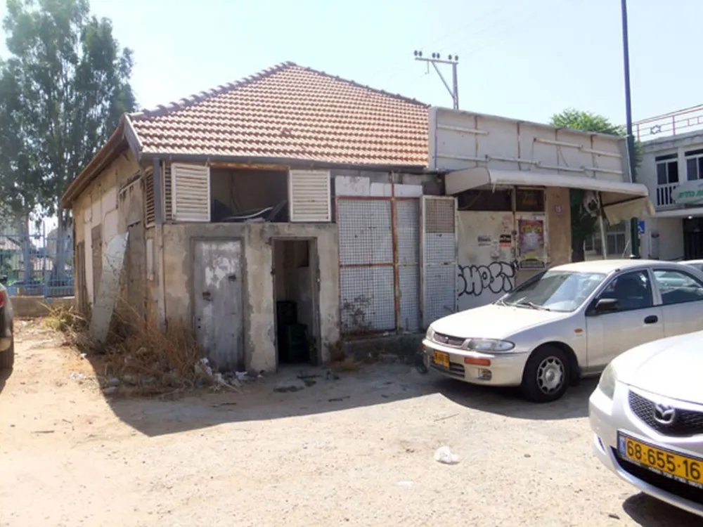 dilapidated house with two cars in the foreground