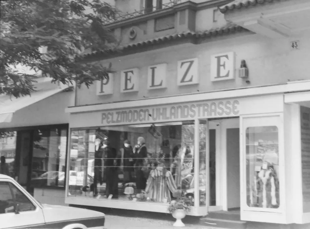 Black-and-white photograph: Store with storefront and a sign meaning “Furs”