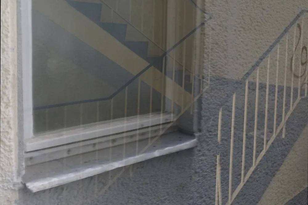Color photo: Reflection in a windowpane showing stairwell