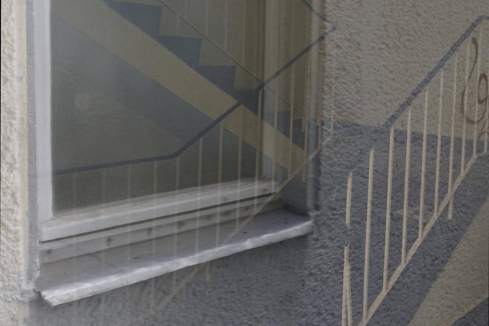 Farbfoto: Spiegelung in einer Fensterscheibe mit Treppenhaus 