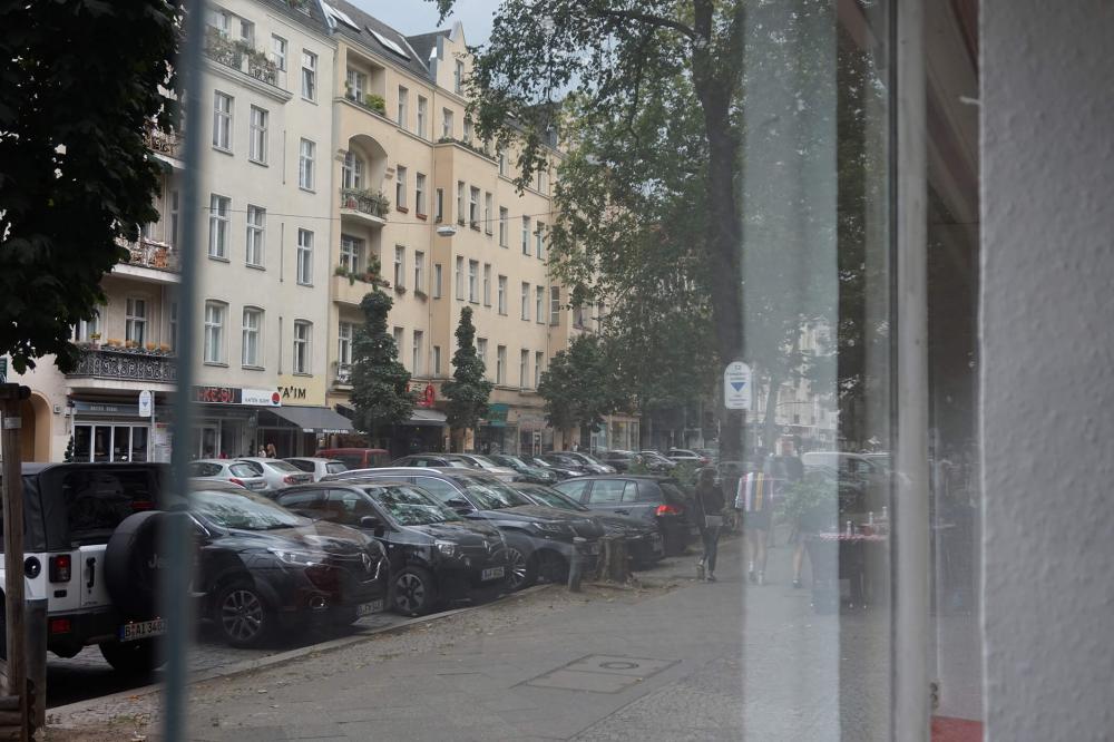 Farbfoto: Blick durch eine Schaufensterscheibe auf Berliner Altbauten 