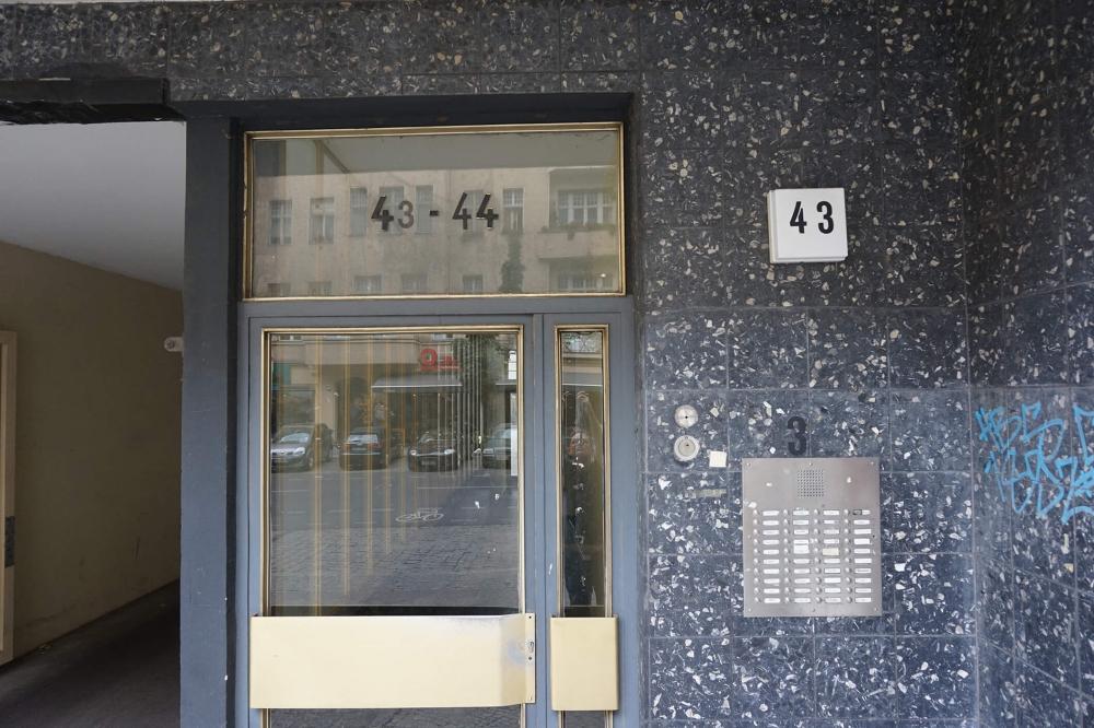 Color photo: Glass front door with the number “43”