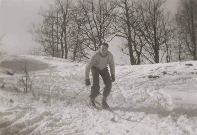 Auf dem Schwarz-Weiß-Foto fährt Walter auf Skiern einen kleinen Abhang hinab.