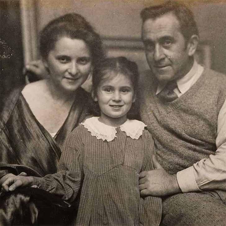 Black-and-white family photograph. Minni and Jakob Steinhardt are seated with Josefa standing between them in a checkered dress and white lace collar. Minni is dressed in a shiny dark tunic, while Jakob wears a wool vest with a shirt and tie.