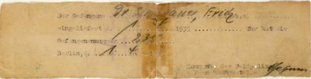 Vergilbter Zettel in extremem Querformat. Darauf sieht man bereits etwas verblichenen Text, teils handschriftlich, teils von einer Schreibmaschine geschrieben