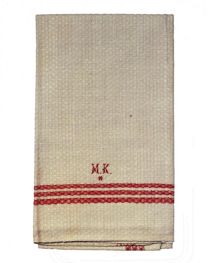 Eine zusammengefaltetes Handtuch mit den gestickten Initialien M.K.