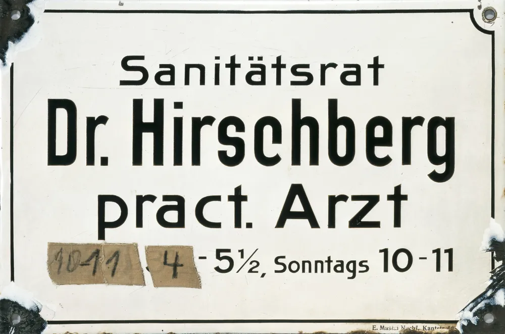 Praxisschild von Dr. Hirschberg mit Angaben zu den Sprechzeiten, die teilweise überklebt sind