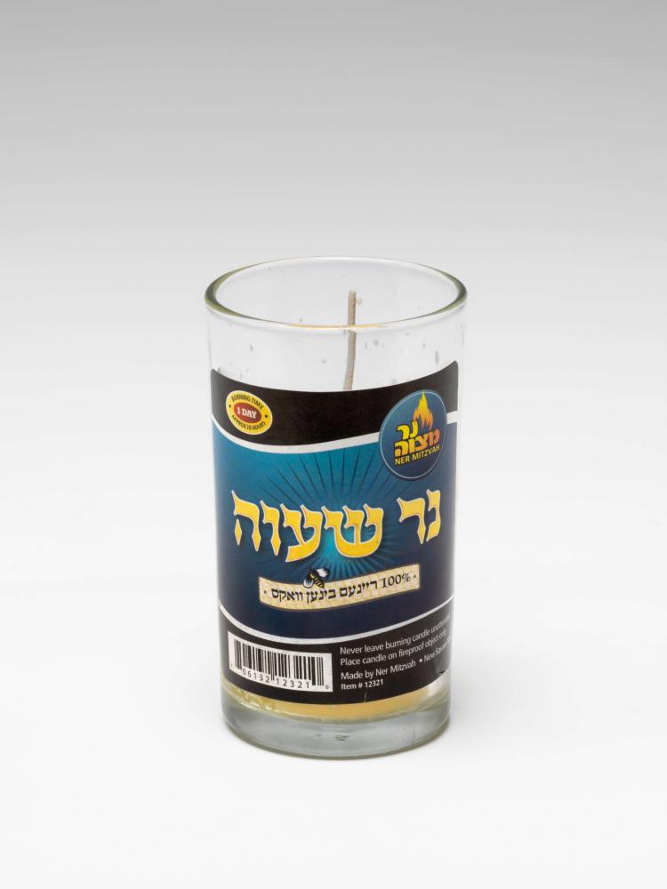 Ein Kerze im Glas mit hebräischer Beschriftung