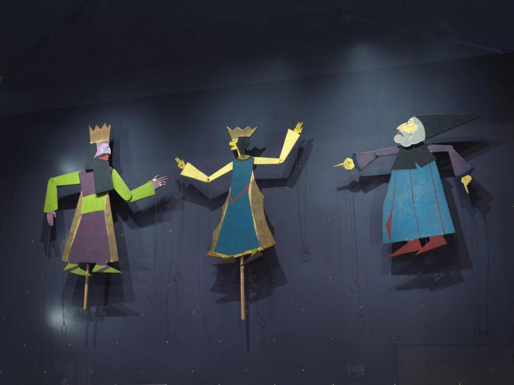 Drei Figuren an jeweils einem Stab befestigte Figuren, zwei mit Krone, einer mit einem spitzen Hut