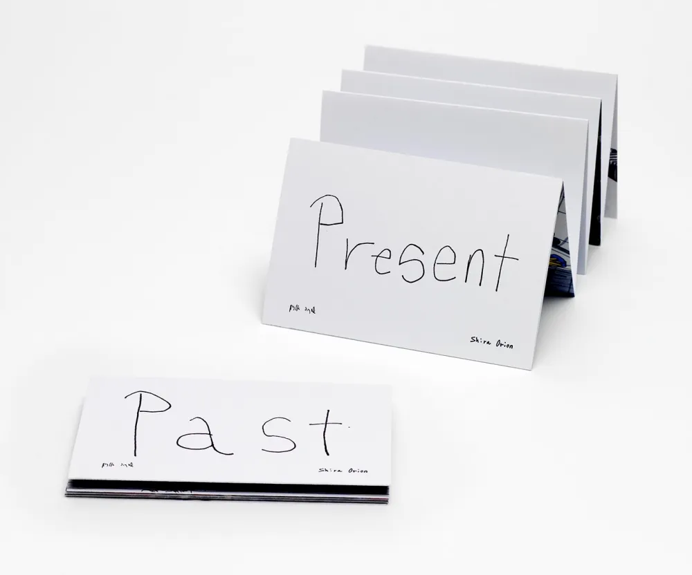 A slightly unfolded book with a concertina binding and the handwritten label “Present” above a closed book labeled “Past”