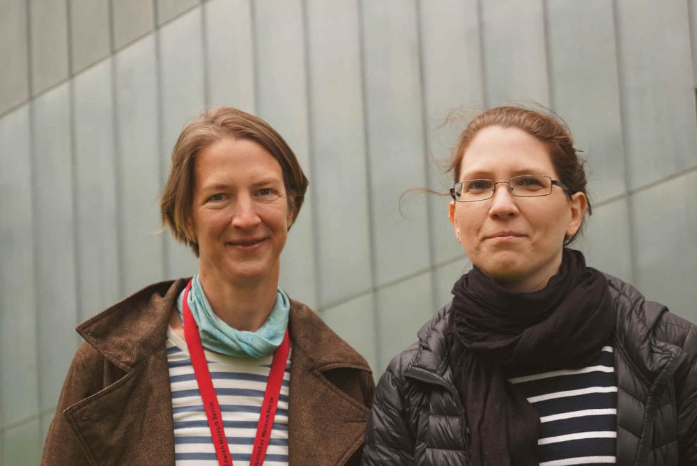 Portrait of Birgit Mauer-Porat and Valeska Wolfram, in the background you can see the metal cladding of the Libeskind Building.