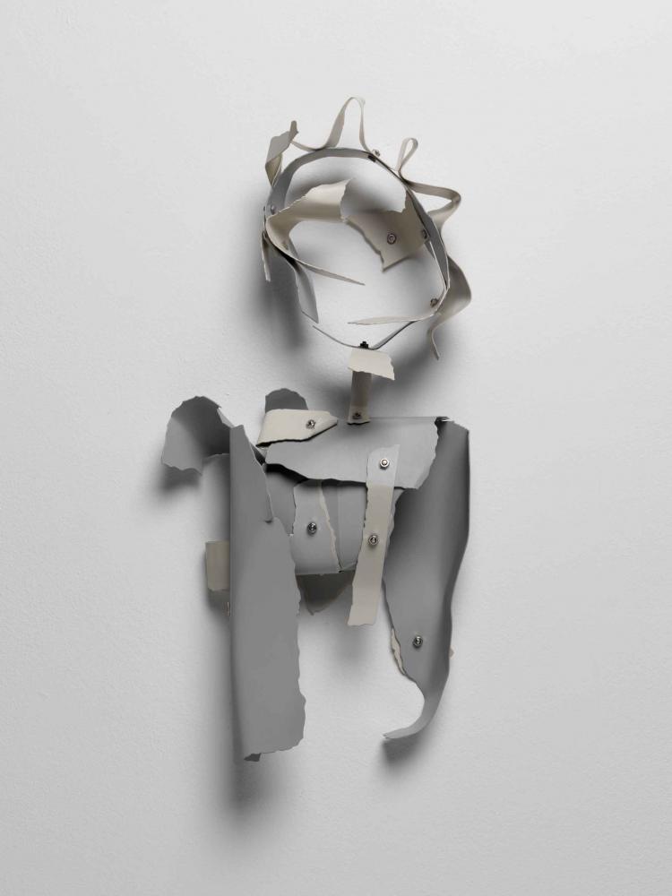 Anthropomorphe Figur aus grauen Fetzen, die von Nieten zusammengehalten werden.