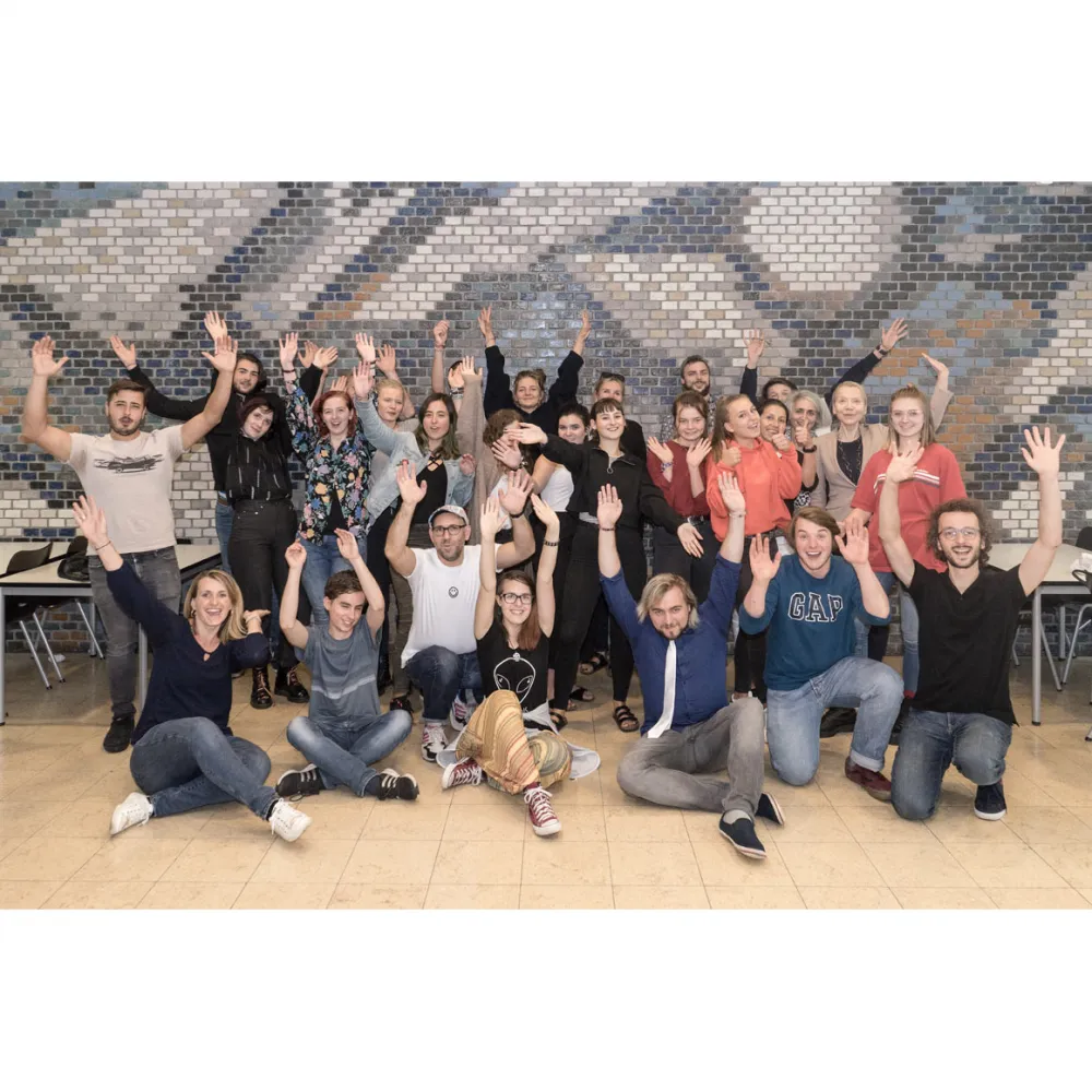 Gruppenfoto mit etwa 20 Jugendlichen, die ihre Arme in die Luft recken