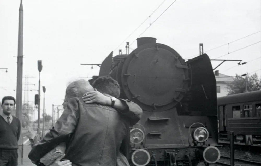 Two men hug at a train station