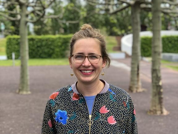 Portrait of Lisa Albrecht with glasses and jacket with flower pattern in the museum garden