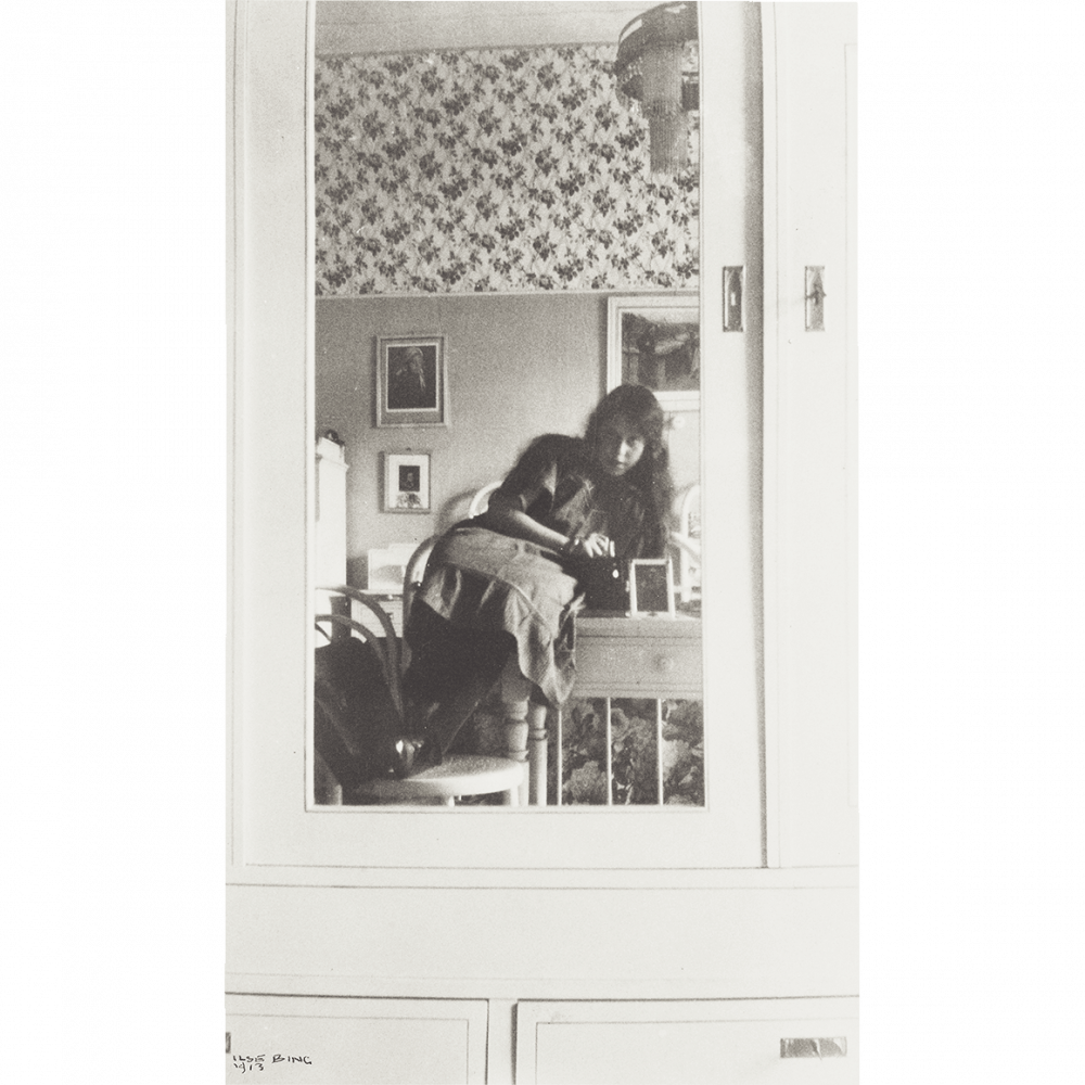 Jugendliches Mädchen in einem Spiegel, der an der Tür eines hellen Schranks befestigt ist