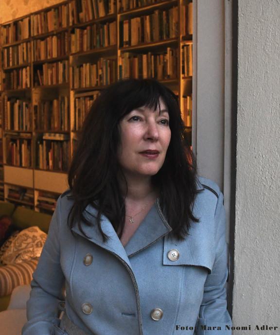 Portrait of Sharon Adler in front of a wall of books
