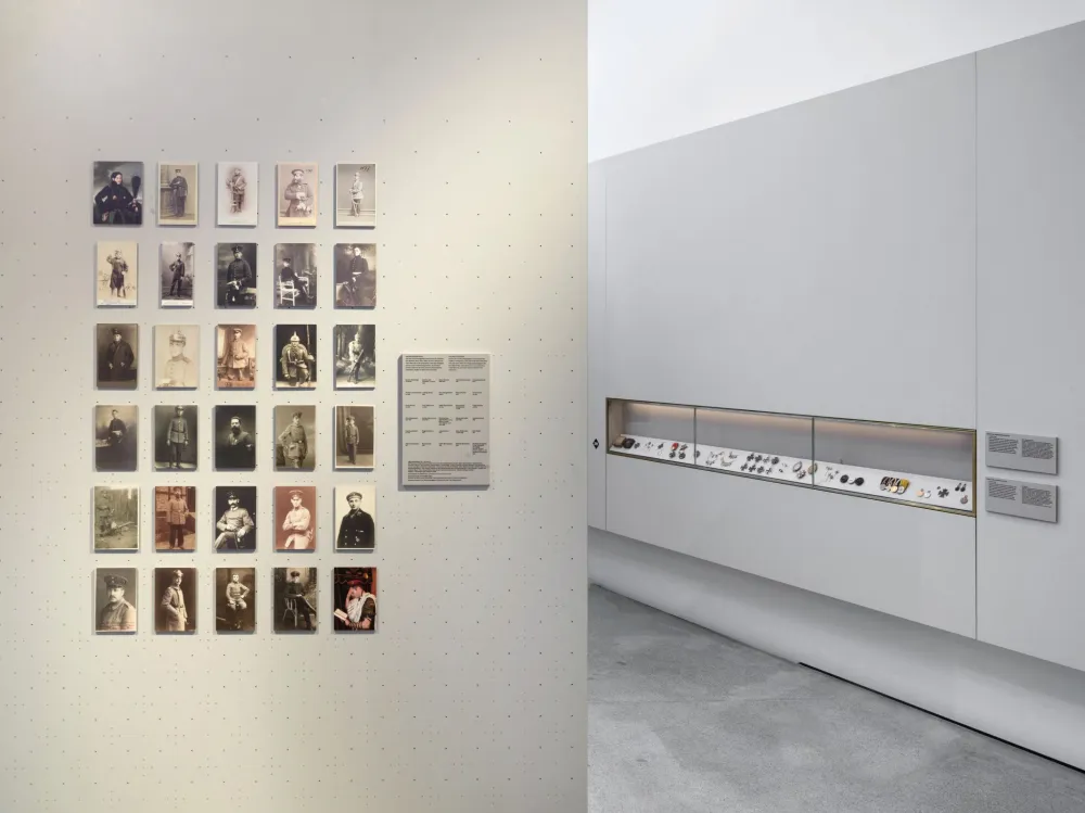 View of an exhiibition room with portraits of soldiers. In the background a showcase with medals