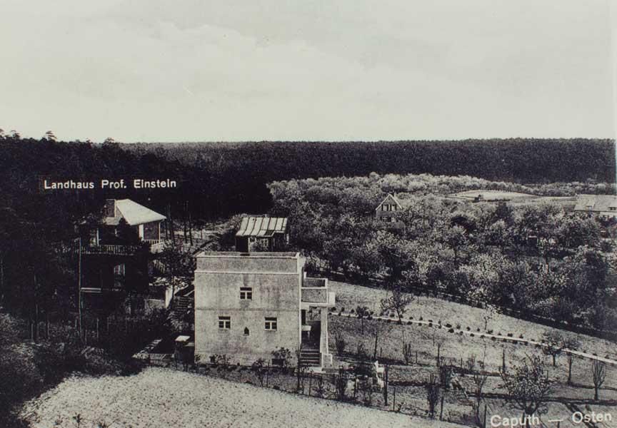 Black and white photograph of two country houses in a hilly landscape.