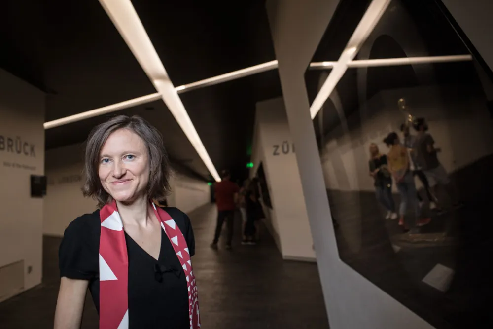 Eine Frau steht vor einer Vitrine in den Achsen des Libeskind-Baus.