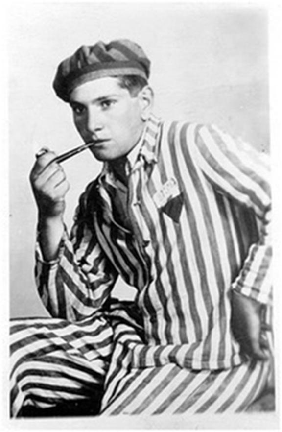 Young man in prisoner’s uniform, casually smoking a pipe