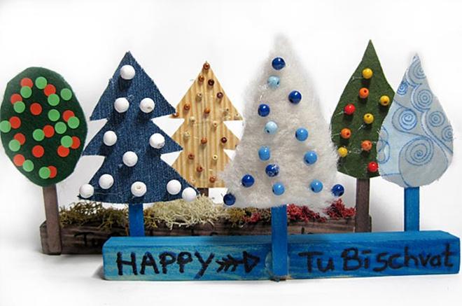 Five colorful, handcrafted trees on a pedestal with the inscription "Happy Tu bi-schwat"