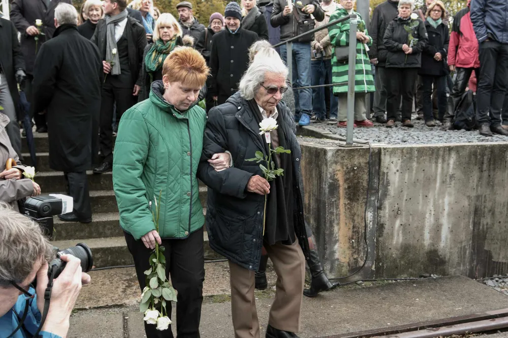 Horst Selbiger mit Petra Pau bei einer Gedenkveranstaltung, in der Hand eine weiße Rose