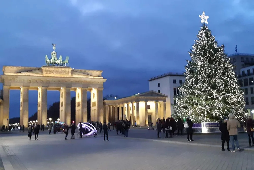 Christmas tree on Pariser Platz with the illuminated Brandenburg Gate in the background