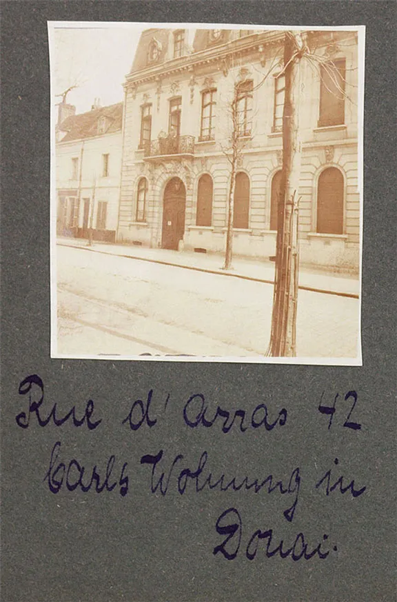 Schwarz-weiß Fotografie eines Hauses mit Straßenausschnitt, eingeklebt in einem Fotoalbum, mit Bildunterschrift.