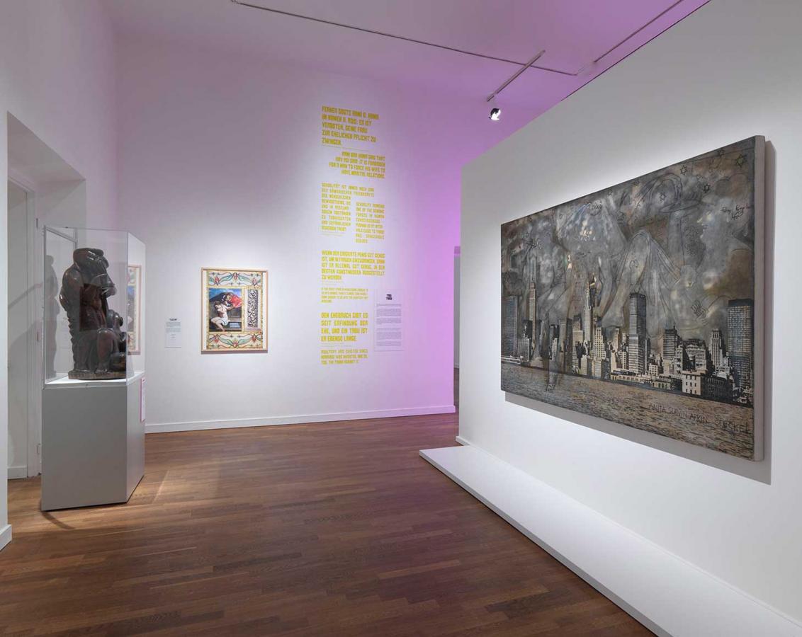 Ausstellungsansicht, links im Raum steht eine Skulptur in einer Vitrine, rechts hängt ein Gemälde an der Wand.