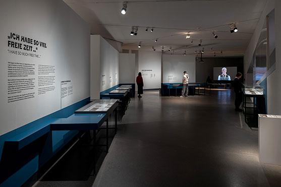 Room view of the exhibition "Het Onderwater Cabaret": on the left you can see showcases along the wall, at the end of the room a large screen with video projection.