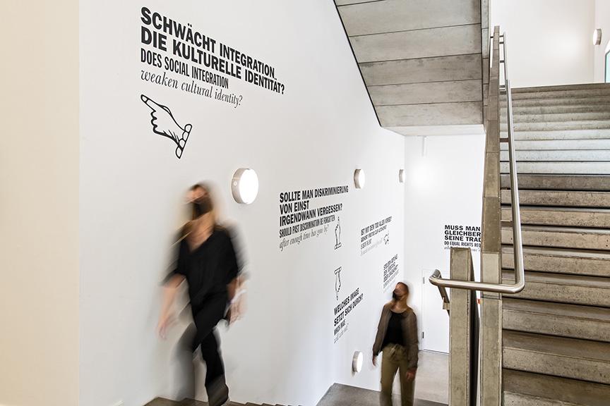 Treppenaufgang mit Wandbildern aus der Moses Mendelssohn Ausstellung mit Besucherinnen 