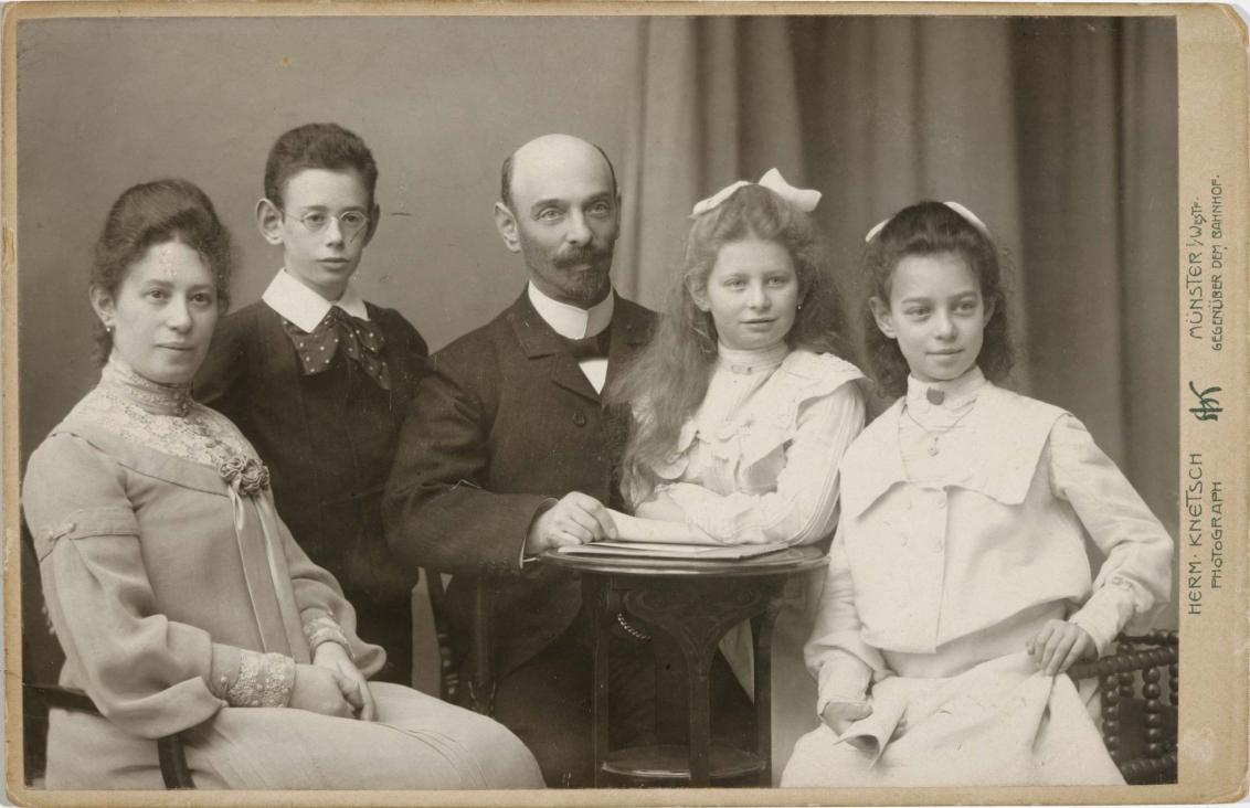 Black-and-white studio photograph: couple with two daughters and a son