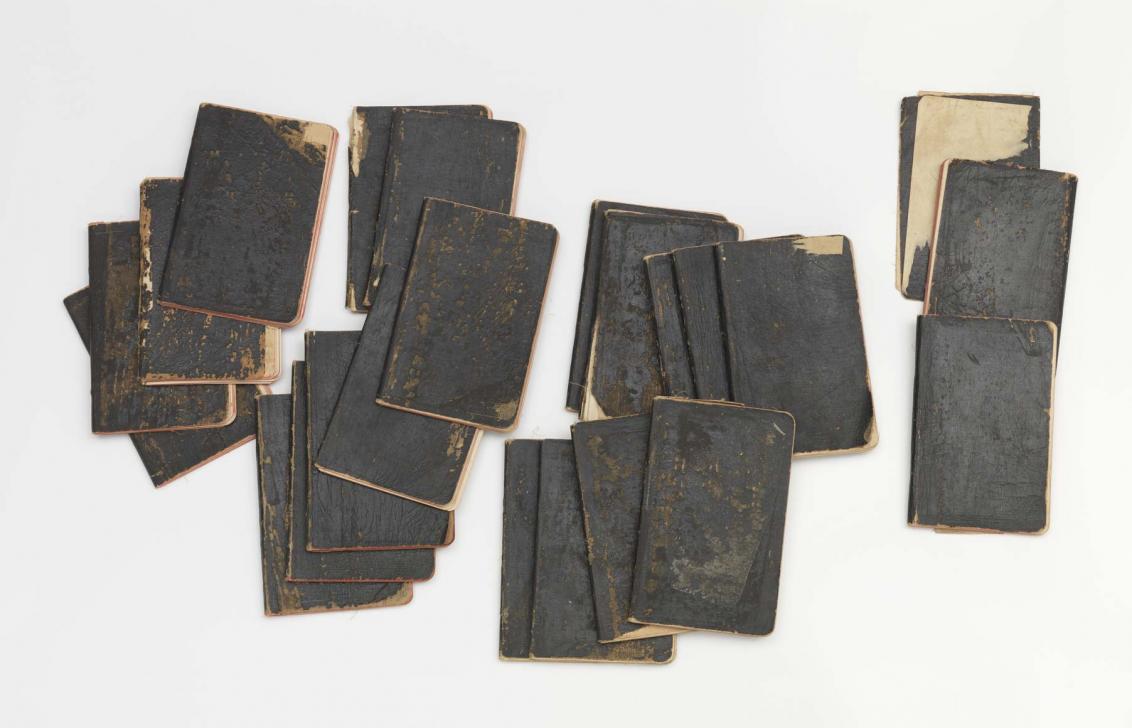 Twenty-three notebooks with black bindings