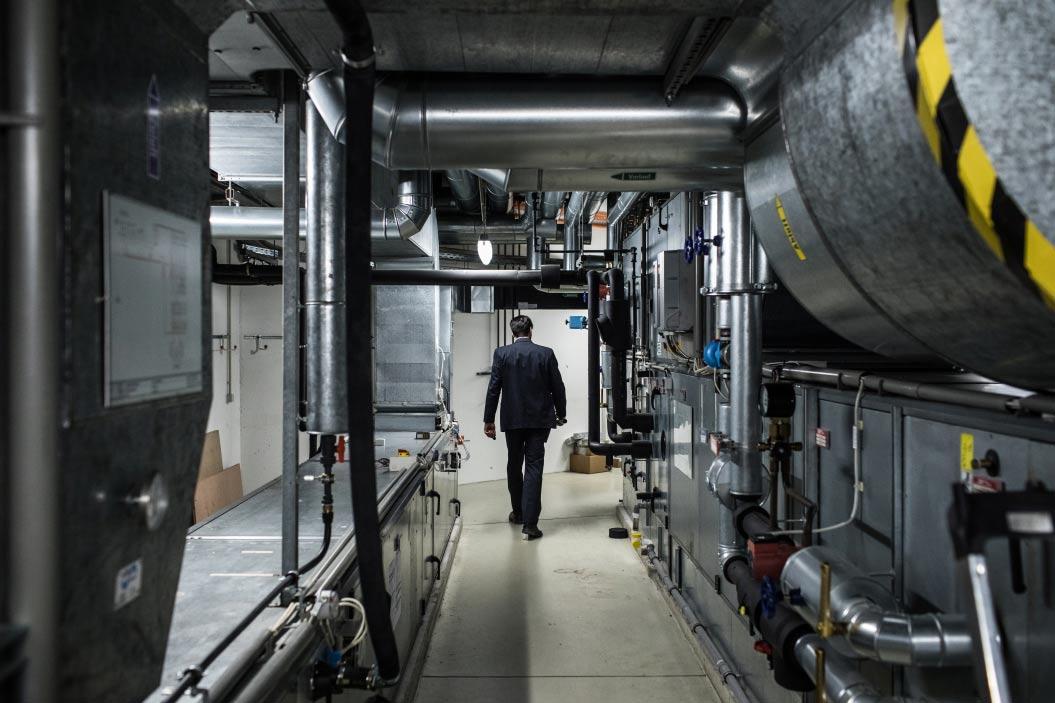 A security guard walking along a basement corridor