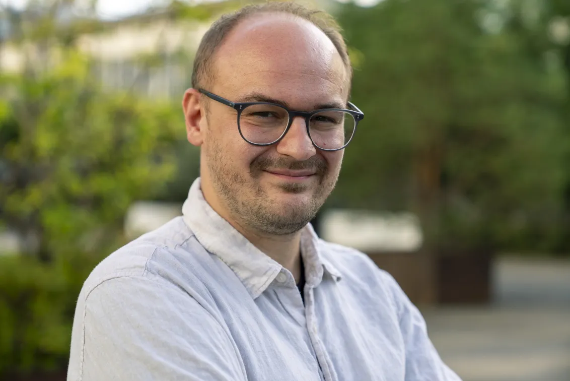 Mann mit Brille schaut freundlich in die Kamera.