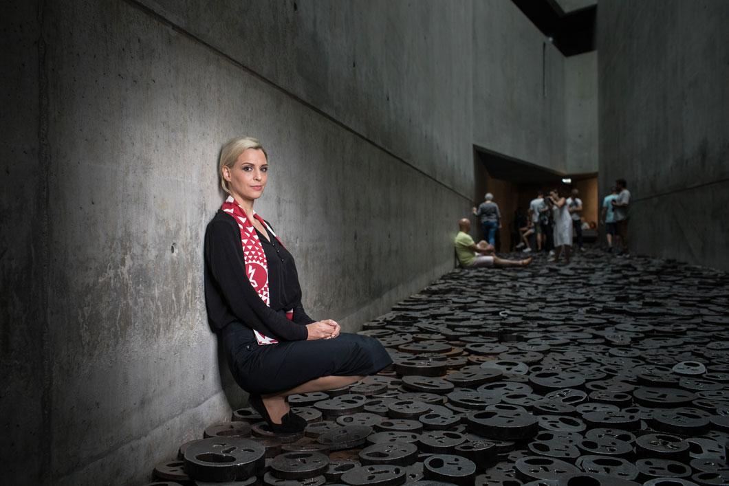 Eine junge Frau sitzt im Memory Void des Jüdischen Museums Berlin