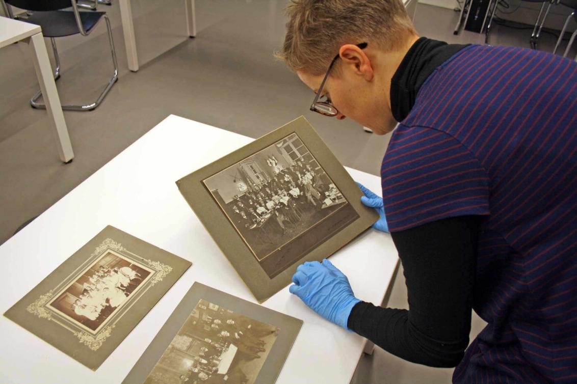 A person examines old photographs.