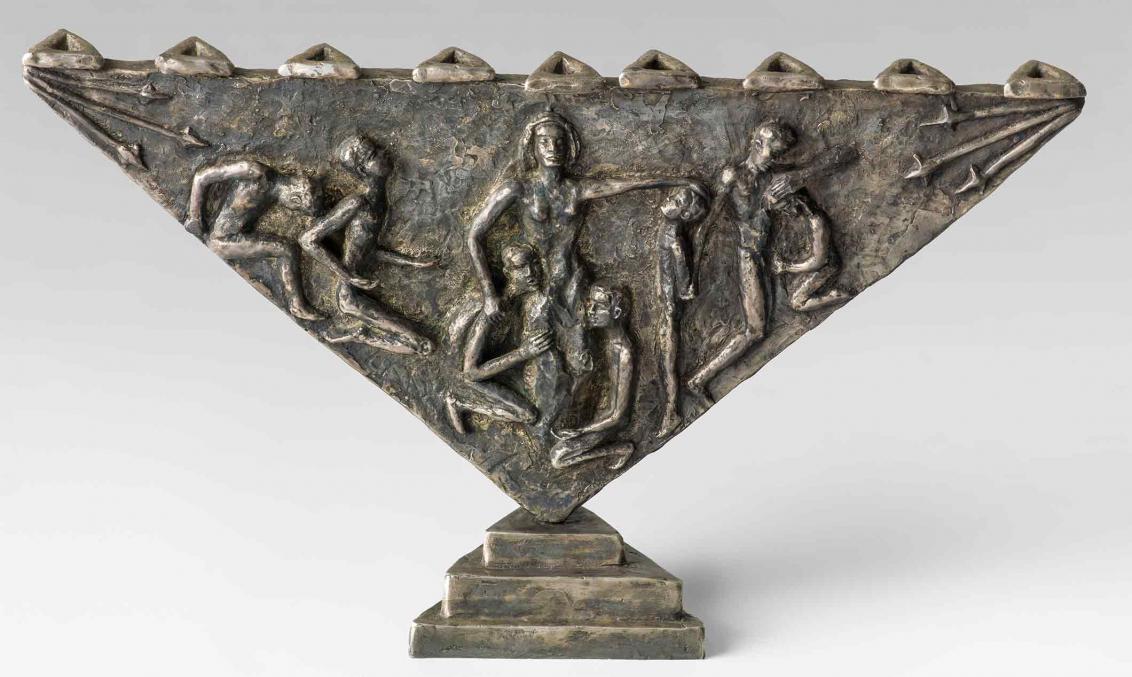 Bronze candelabrum in the shape of a triangle balancing on one point. Reliefs on the side portray a woman and seven men cowering, lamenting, and mourning. The depiction is based on the martyrdom story of Channa and her seven sons.