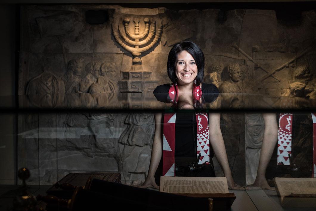 Eine lachende Frau steht in einem Raum der Ausstellung „Welcome to Jerusalem“