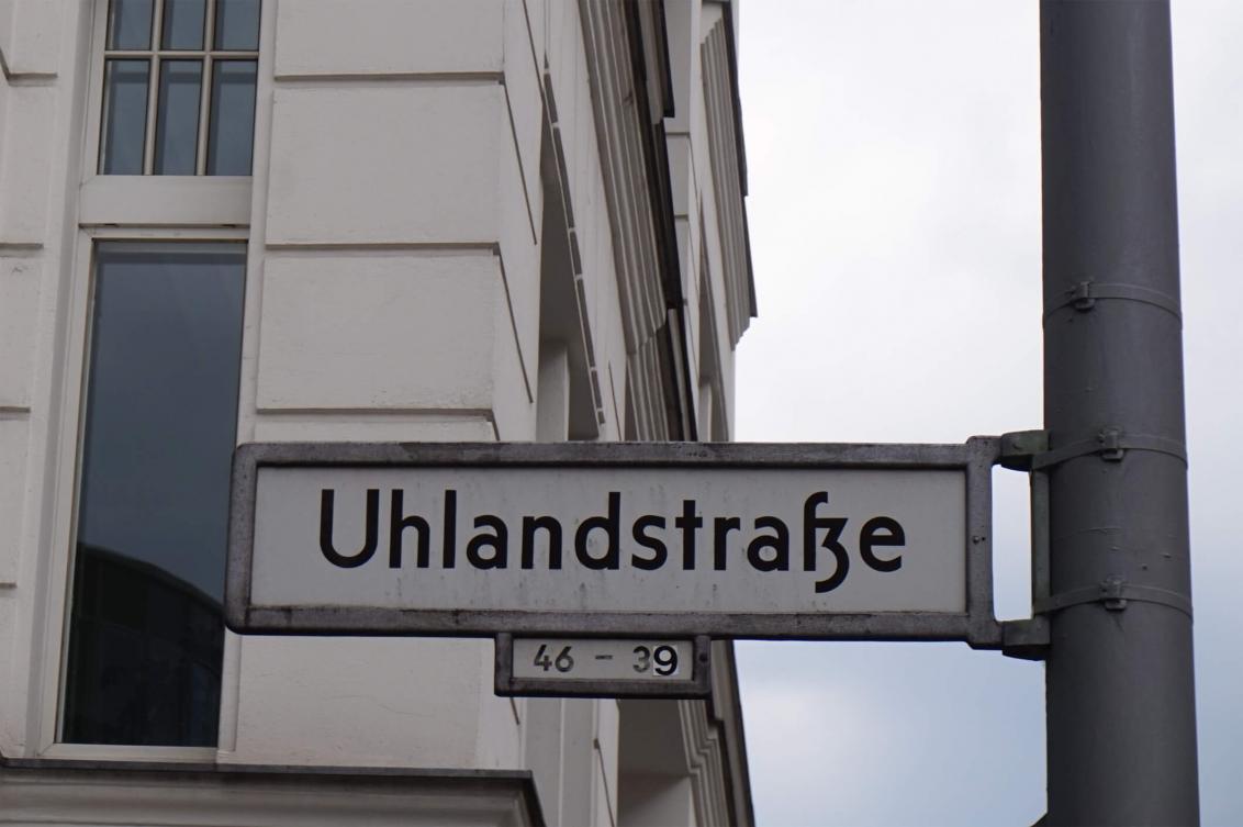Color photo: Street sign in front of a prewar Berlin building