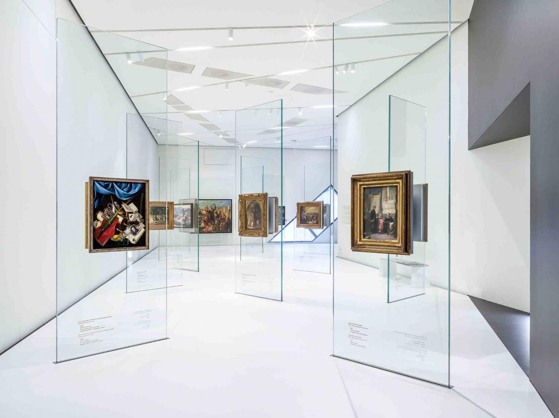 White room, glass steles on which paintings hang
